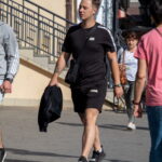 Фото мужчины с татуировками на предплечье и плече. Рисунок татуировки выполнен в темных тонах. Мужчина одет в черную футболку и шорты.
