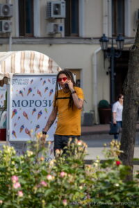 Фото мужчины с дредами, говорящего по телефону. На руках и шее видны татуировки в темных тонах. Рисунок татуировки выполнен в стиле графика.