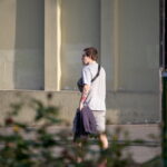 Фотография татуировки на руке мужчины, изображающей яркие цветы и растительные элементы. Татуировка выполнена в насыщенных цветах.
