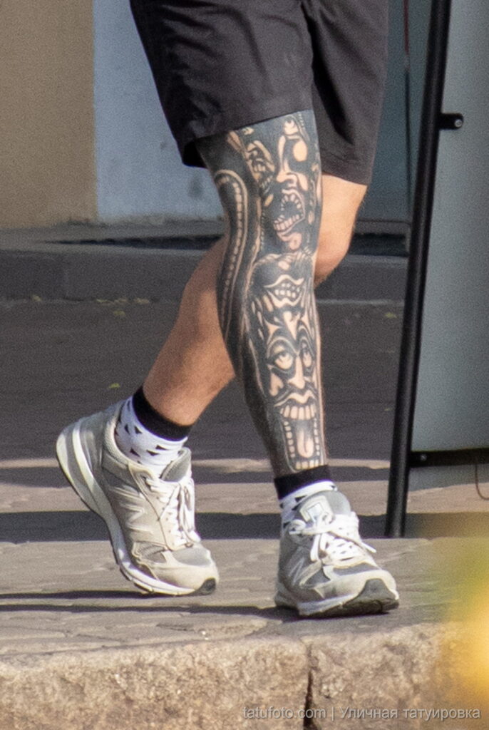 парень с чёрными татуировками узорами и лицами на правой ноге41 - Уличная тату 22062022 №696 - tatufoto.com