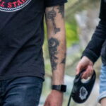 Фото татуировки на руке мужчины: реалистичный рисунок ключа и черепа в черных тонах. Детализированный эскиз татуировки, выполненный опытным мастером.