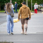 Фото тату на икре мужчины: реалистичный рисунок розы с листьями в черно-серых тонах. Детализированная проработка лепестков и стебля.