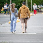 Фото тату тигра и девушки на икре мужчины. Реалистичный черно-серый рисунок татуировки, детализированные портреты и текстуры.