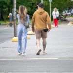 Фото тату тигра и девушки на икре мужчины. Реалистичный черно-серый рисунок татуировки, с акцентом на детализацию портретов и текстур.