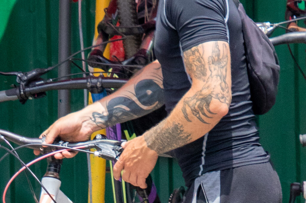 велосипедист с крупной черной татуировкой змеи на всю правую руку16