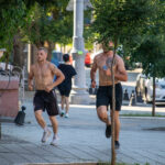два парня с голым торсом и татуировками на теле бегают в центре города35