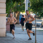 два парня с голым торсом и татуировками на теле бегают в центре города36