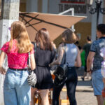 Фото татуировки на руке девушки. Татуировка выполнена в черных тонах и представляет собой сложный узор с цветами и листьями.