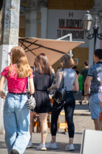 Фото татуировки на руке девушки. Татуировка выполнена в черных тонах и представляет собой сложный узор с цветами и листьями.