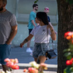 Фотография девушки в белой футболке и джинсовых шортах с татуировками на руке и ноге. Видна татуировка в виде птицы.