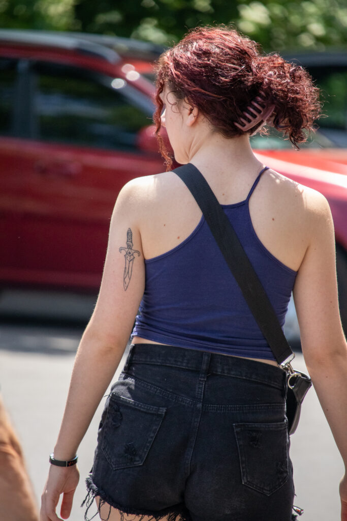 молодая девушка с татуировкой кинжала около левой лопатки 1