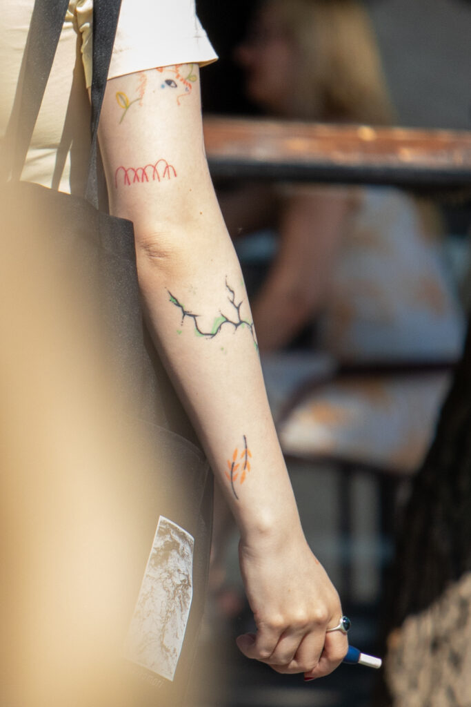 молодая девушка со смешными цветными татуировками на правой руке07