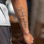 молодой мужчина с татуировкой надписью про семью на запястье правой руки35
