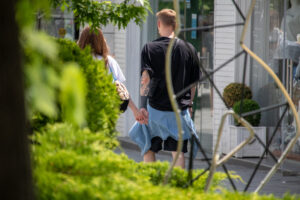 Фото тату: Мужчина с татуировкой на руке идет за руку с девушкой. Видна часть татуировки в японском стиле.
