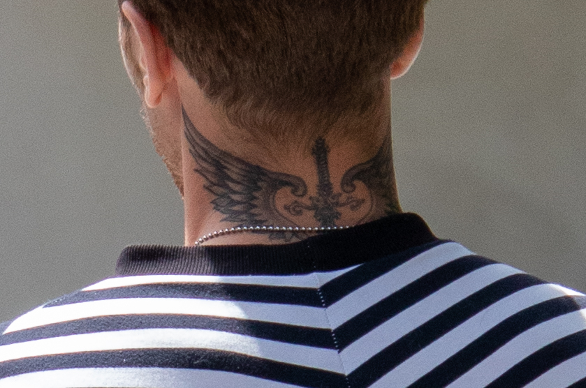 молодой парень с татуировкой Меч и крылья на шее сзади36