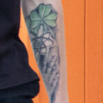 молодой парень с татуировкой клевер символ атома и ладонь на левой руке48