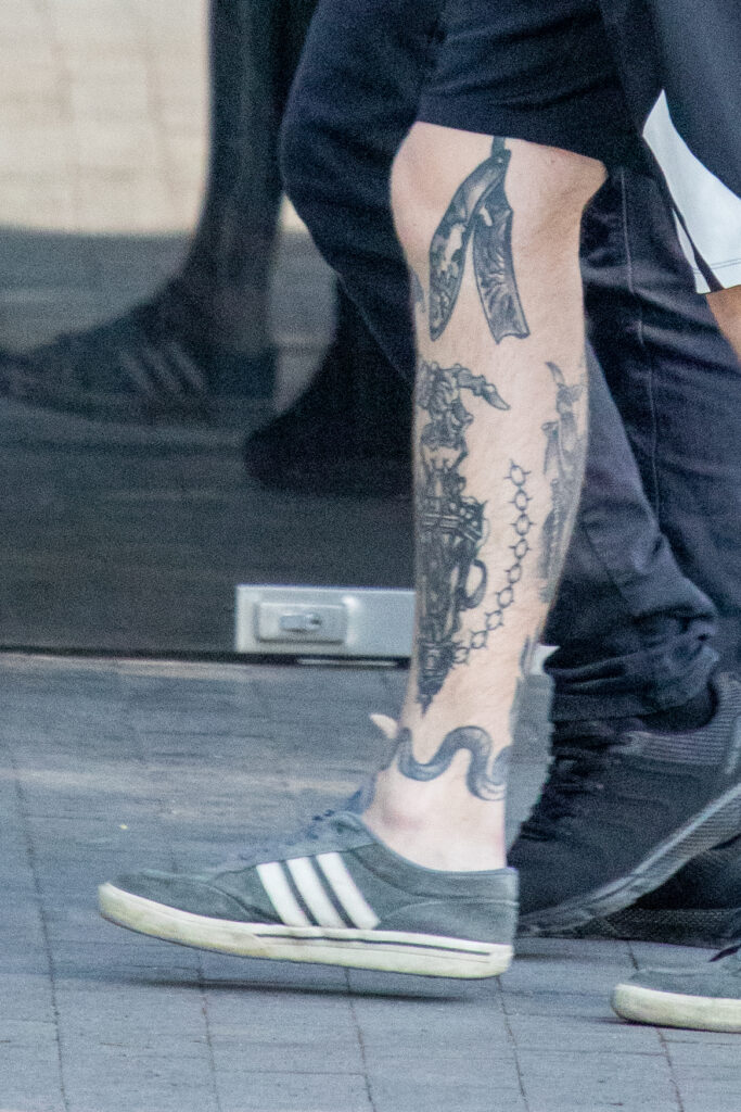 молодой парень с татуировкой опасная бритва змея цепь и уличный фонарь внизу ноги35
