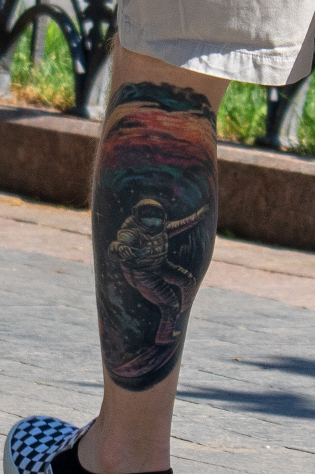 молодой парень с цветной татуировкой внизу левой ноги астронавт на сноуборде в космосе47
