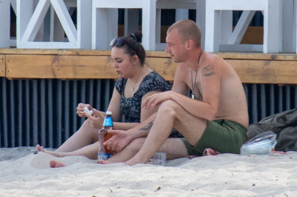 мужчина с татуировками на руке и плече отдыхает на пляже 2