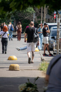 Фото тату на икре мужчины, идущего по улице. Видна татуировка с изображением головы медведя в реалистичном стиле.