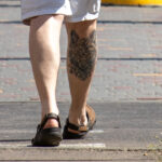 мужчина с татуировкой волк узорами внизу правой ноги 8