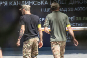 Фотография двух мужчин с татуировками на руках, одетых в военную форму. Видны татуировки на предплечьях и бицепсах.