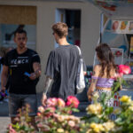 Фотография мужчины и девушки с татуировками на руках, идущих по улице. Мужчина в черной футболке, девушка в лиловом топе.