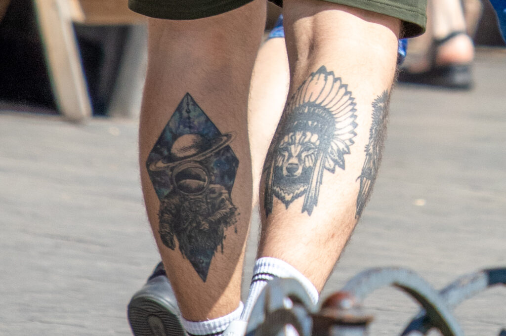 парень с татуировками внизу ноги Ром космонавт Планета Волк в индейской шляпе00
