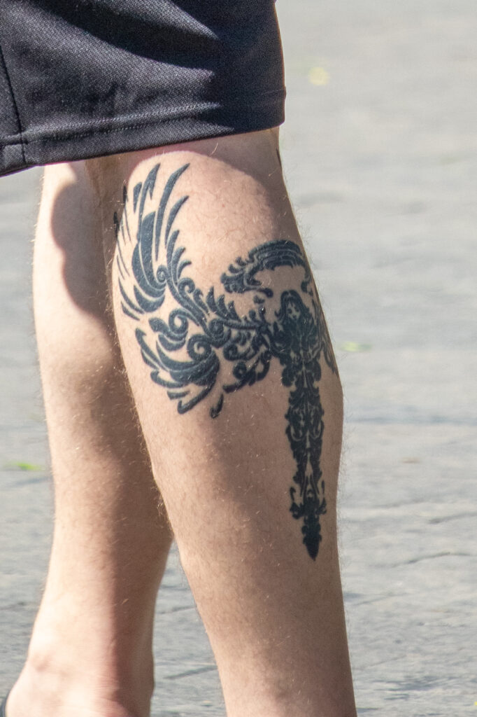 парень с татуировкой ангел воин с крыльями внизу левой ноги16
