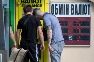 Фото тату на руке мужчины, стоящего у обменного пункта. Татуировка выполнена в стиле реализм, изображает детализированный рисунок.