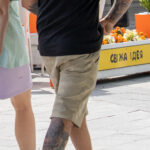 парень с татуировкой из цветов и листьев на руке и ноге 5