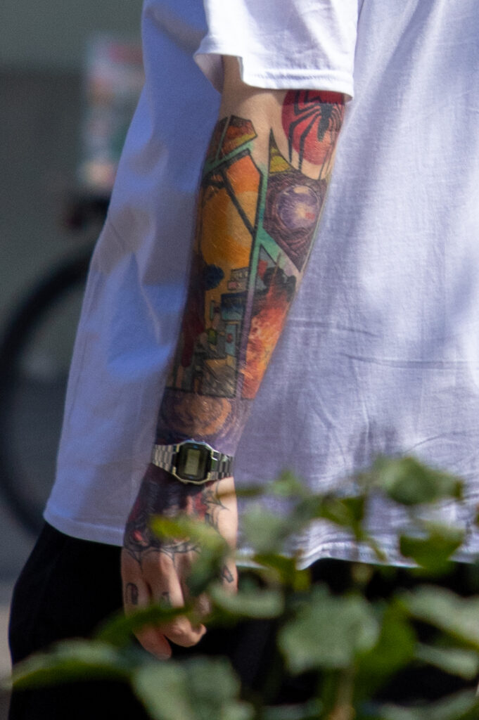 парень с яркими цветными татуировками на левой руке и шее55