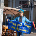 пожилой мужчина в одежде Супергероя стилизованное под флаг Украины и надписью сделай что-нибудь полезное для Украины34