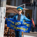 пожилой мужчина в одежде Супергероя стилизованное под флаг Украины и надписью сделай что-нибудь полезное для Украины36