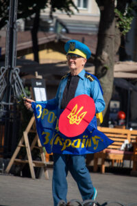 Фото мужчины в костюме казака с саблей и щитом. Яркий образ с украинской символикой.