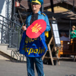 Фото мужчины в костюме казака с саблей и щитом. Яркий образ с украинской символикой.