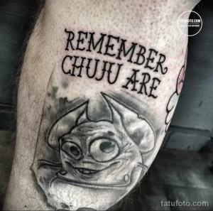Фото тату с изображением Чужого из фильма "Чужой" и надписью "Remember Chujju Are" в стиле black and grey. Детализированный рисунок с использованием теней и полутонов.