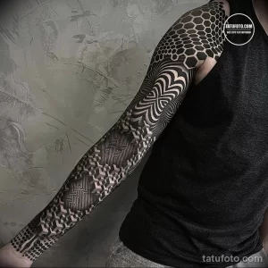 Фото тату в виде геометрического рукава, выполненного в стиле blackwork. Сложные узоры, состоящие из линий, точек и фигур.