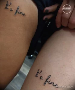 Фото тату: минималистичная надпись 'It's fine' на руке, выполненная тонкой линией. Простой и лаконичный рисунок татуировки с ироничным смыслом.