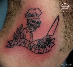 Фото татуировки с изображением черепа в поварском колпаке, держащего нож, и надписью 'Bon Appetit', выполненной в старом стиле.