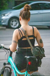 Фото тату на плече девушки: миниатюрные цветы и геометрические линии в черном цвете. Изящный рисунок татуировки подчеркивает женственность.