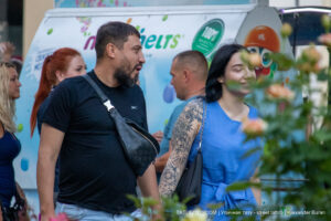 Фото тату на руке: крупный план детализированного черно-серого рисунка черепа, окруженного цветами, выполненного в графическом стиле.