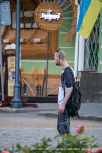 Фото тату на руке мужчины с изображением символа и татуировка на шее. Уличная фотография, street tattoo.
