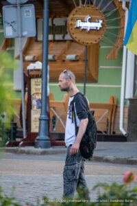 Фото тату на руке мужчины с изображением символа и татуировка на шее. Уличная фотография, street tattoo.