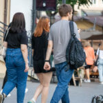 Фото тату: Мужчина с татуировкой на левой руке идет по улице. Татуировка представляет собой схематичное изображение, выполненное в черном цвете.