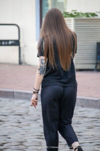 Фотография девушки с татуировкой на руке, вид сзади. Татуировка выполнена в черном цвете, видны детализированные узоры.