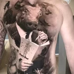 Фото реалистичной татуировки на груди и плече с изображением свиньи в костюме, читающей газету. Детальный рисунок татуировки.