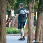 Фото тату на ноге мужчины: яркий рисунок японского карпа кои, выполненный в традиционном стиле с использованием красных, оранжевых и черных оттенков.