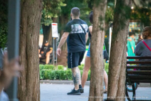 Фото тату на ноге мужчины: яркий рисунок японского карпа кои, выполненный в традиционном стиле с использованием красных, оранжевых и черных оттенков.