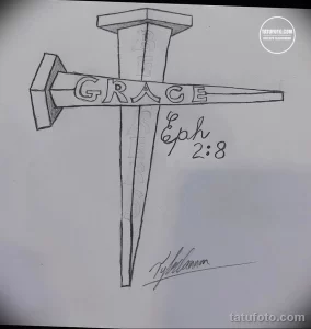Фото эскиза татуировки креста с надписью "Grace" и "Eph 2:8". Рисунок выполнен в черно-белой гамме, с акцентом на каллиграфию.